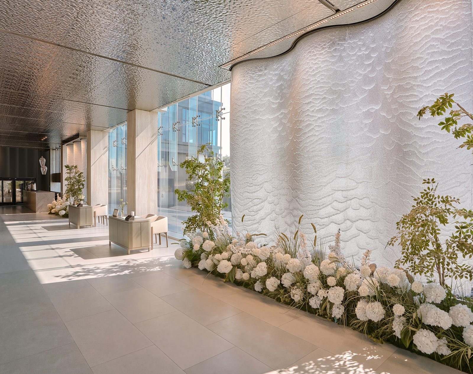 Reception lobby of The Chapel at Saigon, with a sculptural wall and flowers